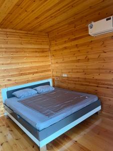a bedroom with a bed in a wooden wall at Cottage Sandro-Sandro in Kinkisha