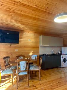 a kitchen and dining room with a table and chairs at Cottage Sandro-Sandro in Kinkisha