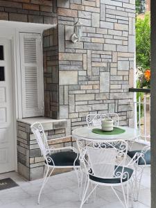 a table and chairs on a patio with a brick wall at Anna-Maria in Nea Kallikrateia