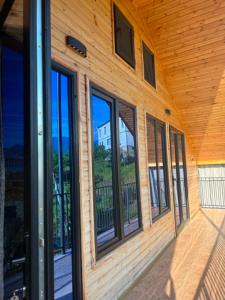 a wooden building with glass doors and windows at Cottage Sandro-Sandro in Kinkisha