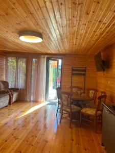 a living room with a wooden ceiling and a table at Cottage Sandro-Sandro in Kinkisha