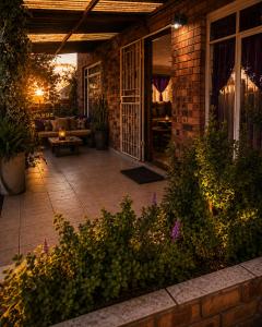 an outdoor patio with a couch and a table at Bushman Kraal Backpackers in Soweto
