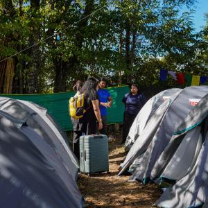 a group of people standing between two tents at Camp Pineyard Ziro in Ziro