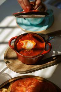 a pot of food with a chicken in tomato sauce at Hotel Štacija in Kaštela