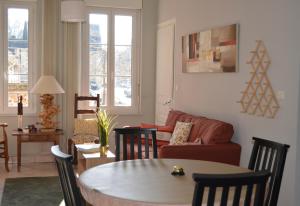a living room with a table and a couch at L Ecureuil Ludique in Beaumont-le-Roger