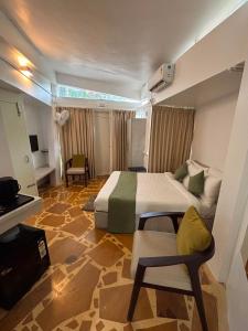 a hotel room with a bed and a chair at Trisara Boutique Stay in Mysore