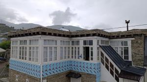 a white and blue building with mountains in the background at Elvin in Küsnǝtqazma