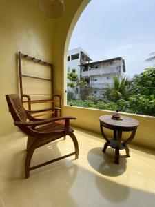 a chair and a table in a room with a window at Surf'n Lanka - Surf School in Weligama