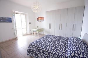 Un dormitorio con una cama azul y blanca y una mesa en Costa Ovest - Goelba, en Fetovaia