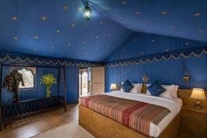 a bedroom with a large bed in a blue room at Marawi Desert Resort in Sām +58 photos
