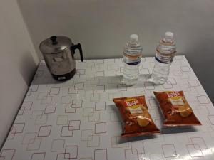 a counter with two bottles of water and some food at Sandy Homestay in Dehradun