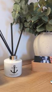 a white container with an anchor on it next to a potted plant at Flotnar Hús - Newbuild B&B in Keiss