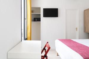 a bedroom with a bed and a tv on the wall at Paris Hostel in Paris