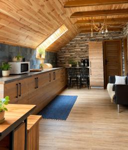 a kitchen with wooden cabinets and a dining room at Farma Puchałowo in Puchałowo