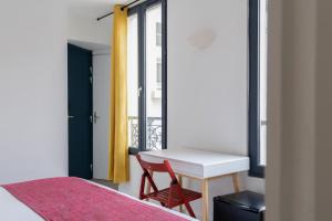 a bedroom with a desk and a bed and a window at Paris Hostel in Paris