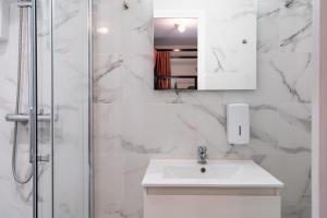 a white bathroom with a sink and a shower at Paris Hostel in Paris +51 photos