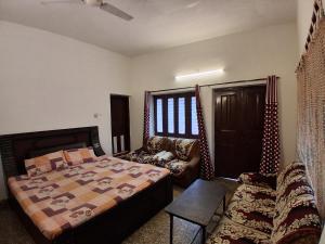 a bedroom with a bed and a couch at Sandy Homestay in Dehradun
