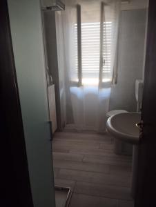 a bathroom with a sink and a toilet and a window at Alice House in Arceto