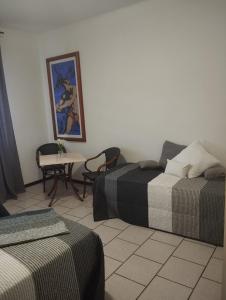 a room with two beds and a table with chairs at Alice House in Arceto