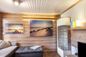 a living room with a couch and pictures on the wall at Ferienhaus 204 in Zadelsdorf