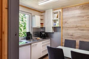 a kitchen with a sink and a counter with chairs at Ferienhaus 204 in Zadelsdorf