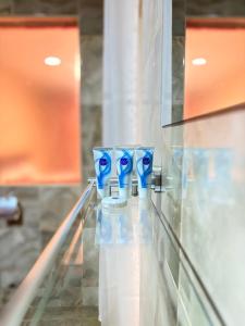 a row of blue glasses sitting on a glass counter at Clavina Hotel in Gilgil +41 photos