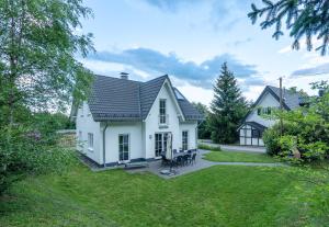 a white house with a patio and a yard at Schneekäppchen 2 in Winterberg
