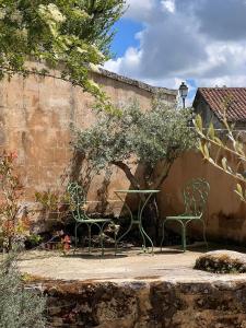 two chairs and a table in a garden at La Maison des Sources in Édon