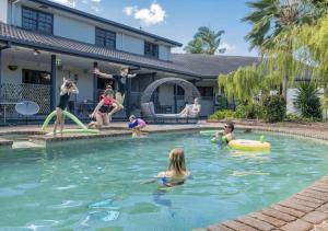 a group of people playing in a swimming pool at Alara Motor Inn in Mackay