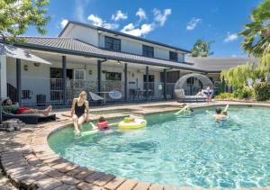 a group of people playing in the swimming pool of a house at Alara Motor Inn in Mackay +62 photos