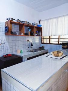 a kitchen with a white counter and a sink at Devkim Stays-Cozy Comfort Near The Beach in Ukunda