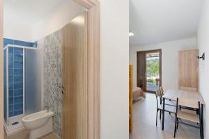 a bathroom with a toilet and a table with chairs at Mammina Holiday Home in Casal Velino +79 photos
