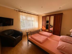 a bedroom with a bed and a black chair at Venta City Apartment in Venta