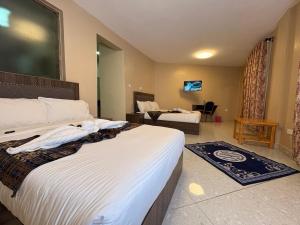 a bedroom with two beds and a living room at Clavina Hotel in Gilgil