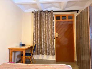 a room with a desk and a door and a table at Clavina Hotel in Gilgil