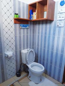 a bathroom with a toilet in a small room at Devkim Stays-Cozy Comfort Near The Beach in Ukunda