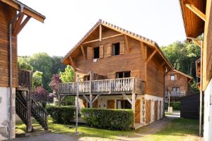 a large wooden house with a balcony on it at Résidence Odalys Les Chalets d'Evian in Évian-les-Bains