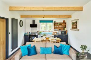 a living room with a couch and a kitchen at The Pig Arc in Bude