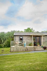 a log cabin with a porch and a lawn at The Pig Arc in Bude