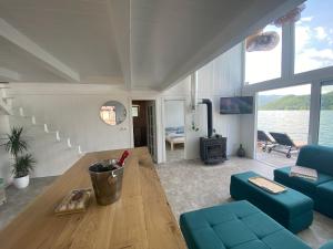 a living room with a blue couch and a table at Viridian Three Boathouse Unique, PERUCAC in Perućac