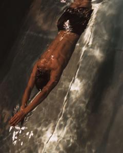 a man laying in the water in the water at Sense Hotel Sofia, a Member of Design Hotels in Sofia