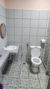 a bathroom with a toilet and a sink at Kelambu Beach Villa in Kudat