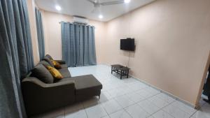 a living room with a couch and a tv at Kelambu Beach Villa in Kudat