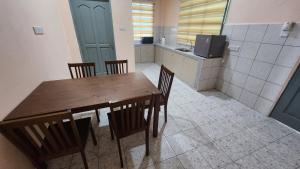 a kitchen with a wooden table and chairs in a room at Kelambu Beach Villa in Kudat +16 photos
