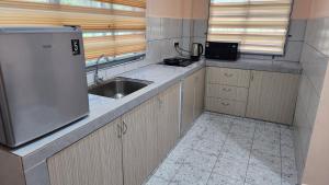 a kitchen with a sink and a refrigerator in it at Kelambu Beach Villa in Kudat