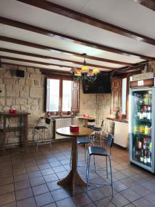 a room with a table and chairs and a refrigerator at Hotel Rural del Médico in Regumiel de la Sierra
