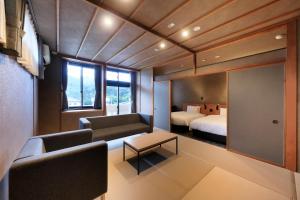 a room with a bed and a couch and a table at 西伊豆 巡り in Ukusu +42 photos