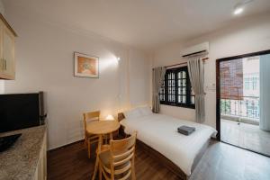 a small room with a bed and a table at Exia House in Ho Chi Minh City