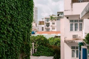 a green wall with buildings in the background at Exia House in Ho Chi Minh City