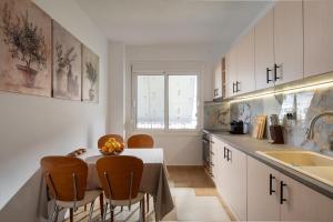 a kitchen with a table and chairs and a sink at Silvia's Haus in Neos Marmaras